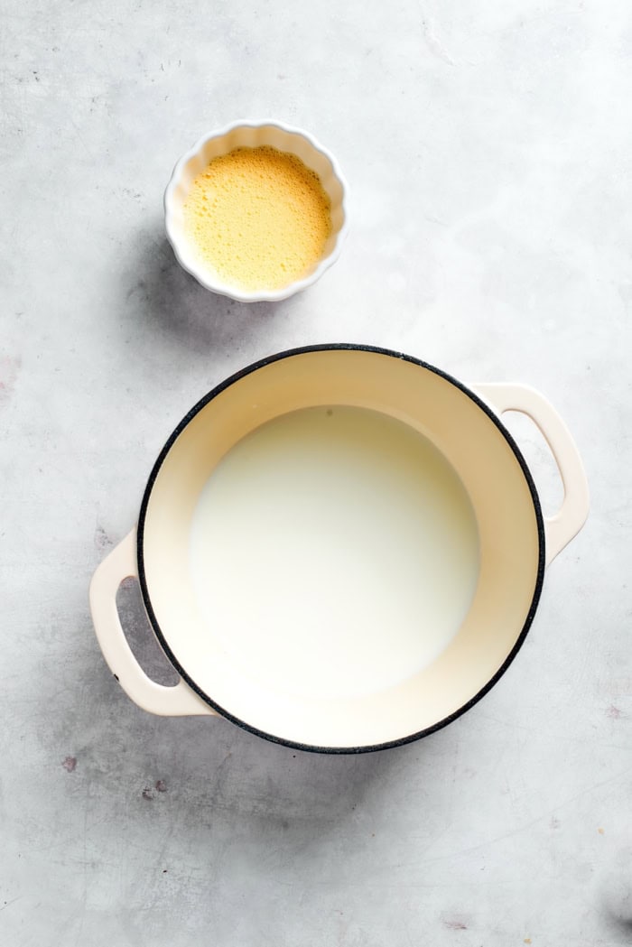 Overhead view of milk in pot and egg mixture in bowl