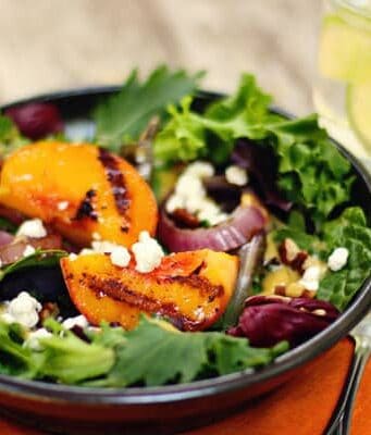 a salad with grilled peaches and onions