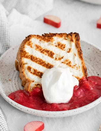 A slice of grilled angel food cake with rhubarb sauce on a plate