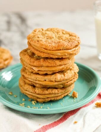 A stack of peanut butter sandwich cookies on a green plate