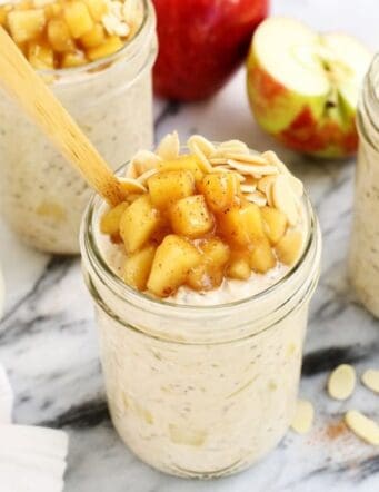 Mason jar of Apple Cinnamon Overnight Oats topped with diced cinnamon apples and sliced almonds