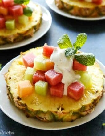 a slice of pineapple with cubes of melon on top