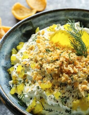 Creamy dill pickle dip topped with diced dill pickles and cracker crumbs