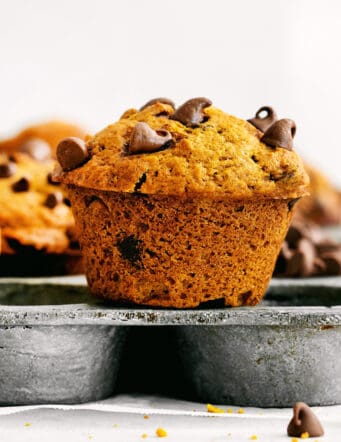 A pumpkin muffin sitting on top of a muffin pan