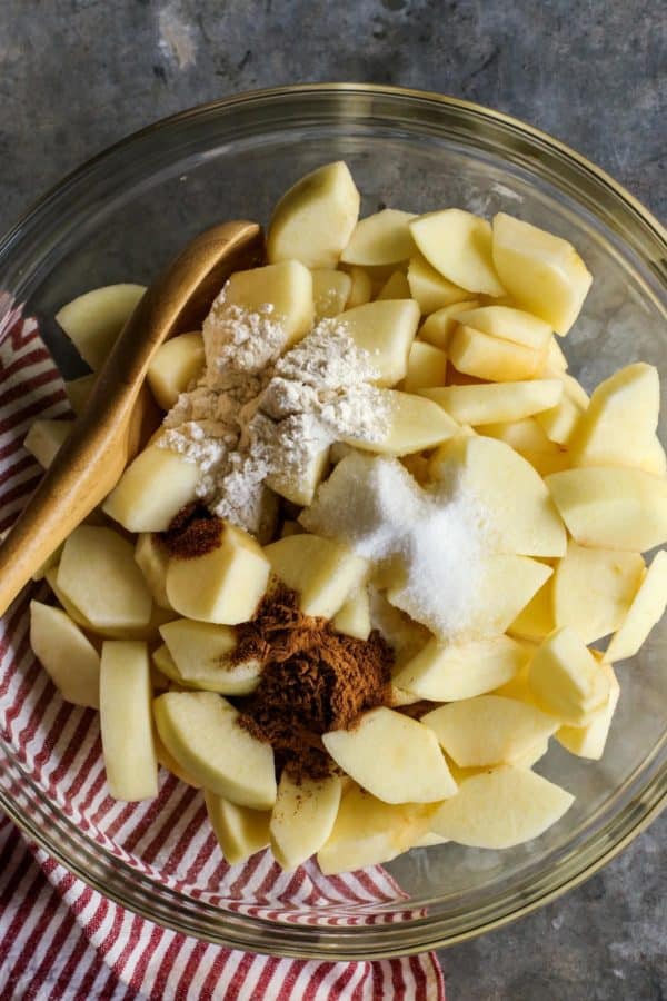Mixing bowl with sliced apples and spices