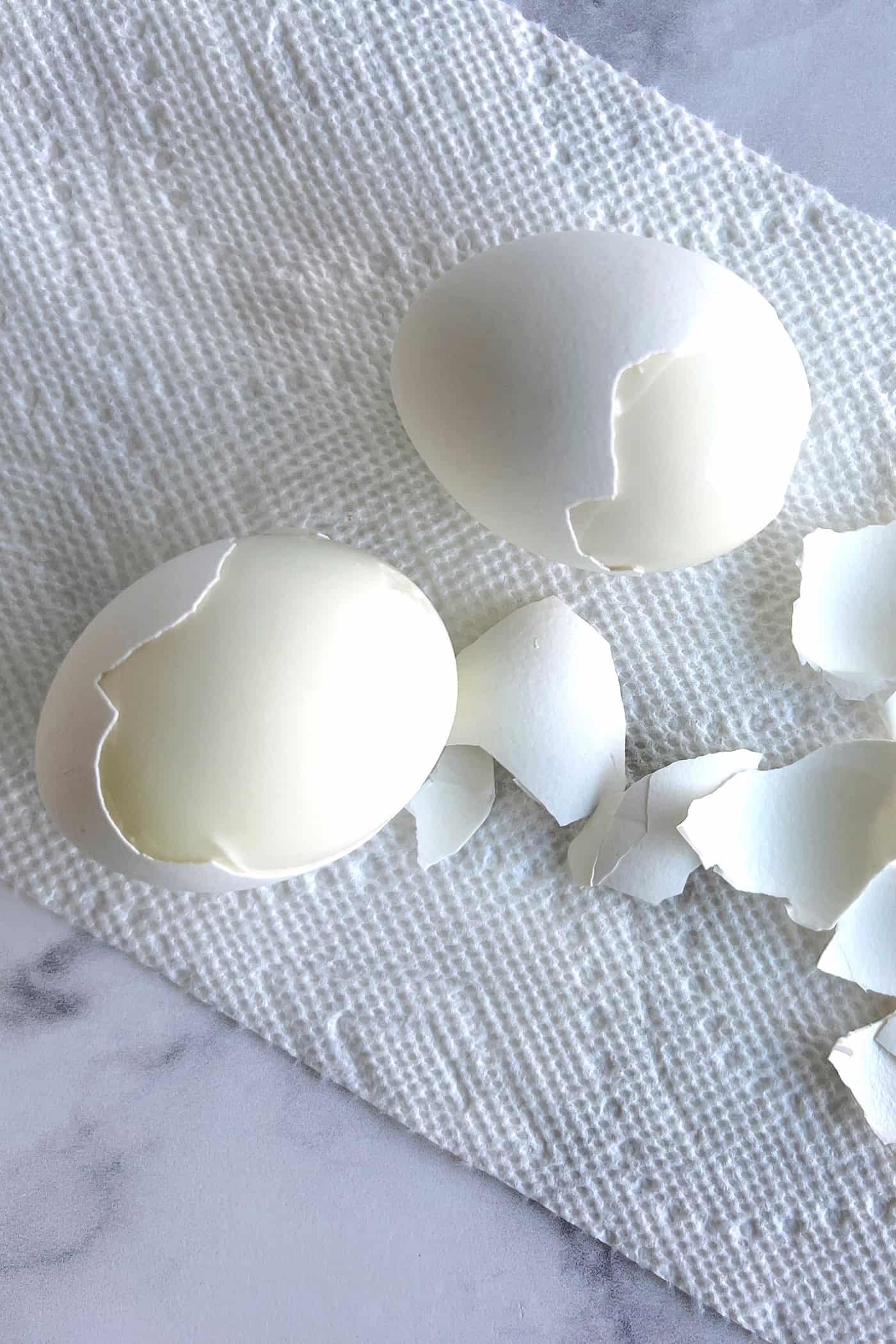 Eggs being peeled on a paper towel