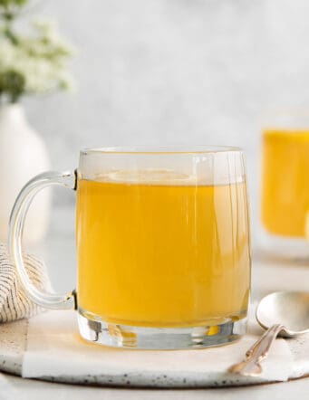 A clear mug of honey citrus mint tea
