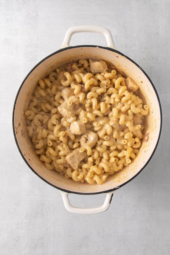 The ingredients for chicken ranch pasta are mixed together in a pot.