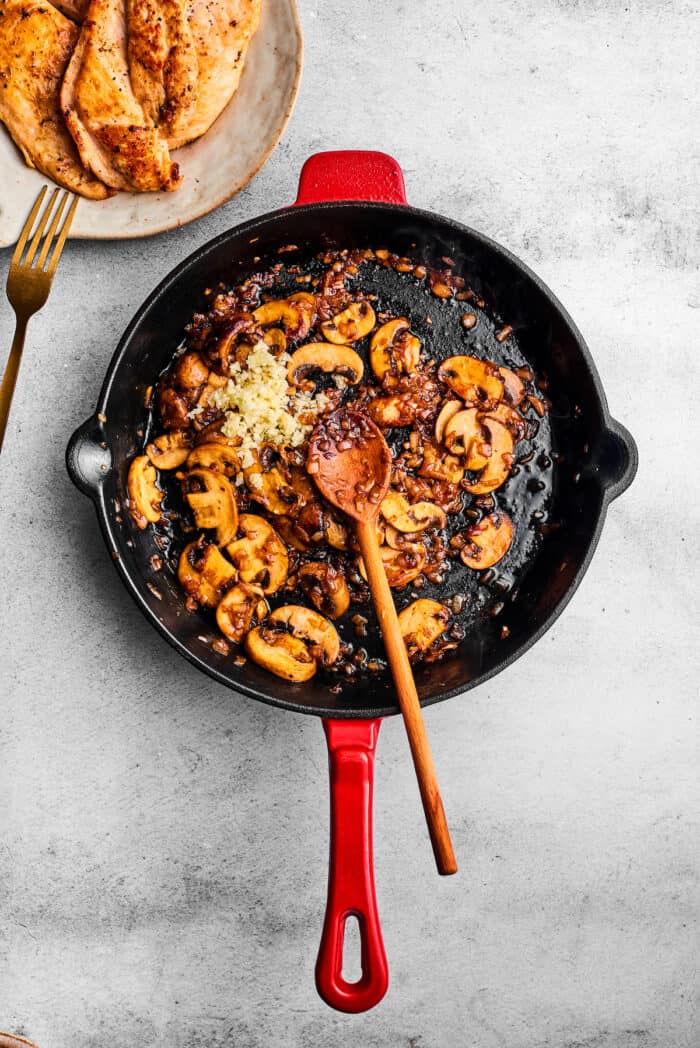 Garlic is added to the skillet of mushrooms.