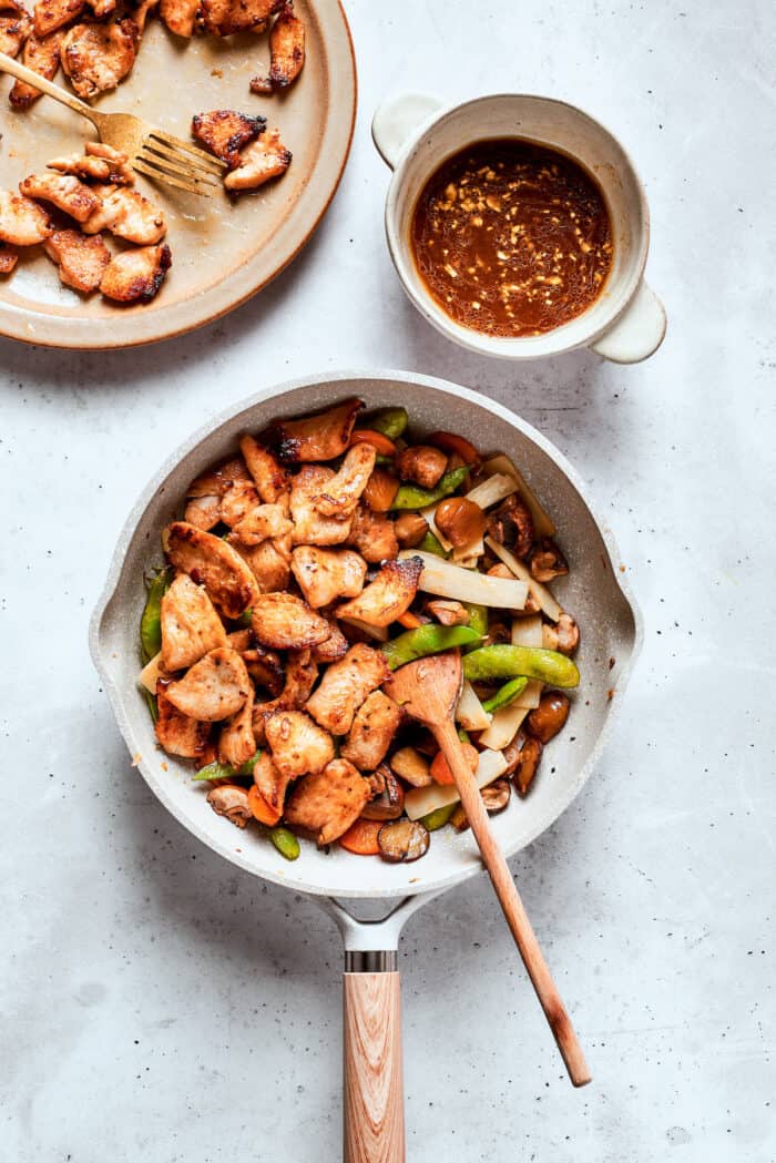 The chicken and vegetables are added to the skillet full of sauce for moo goo gai pan.