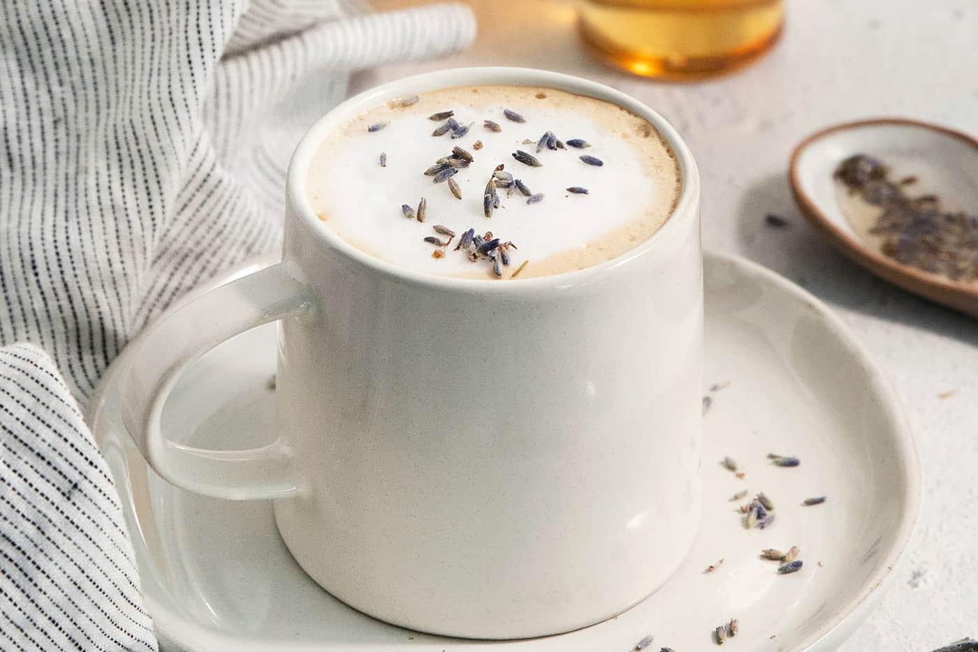 A mug of lavender latte on a plate.