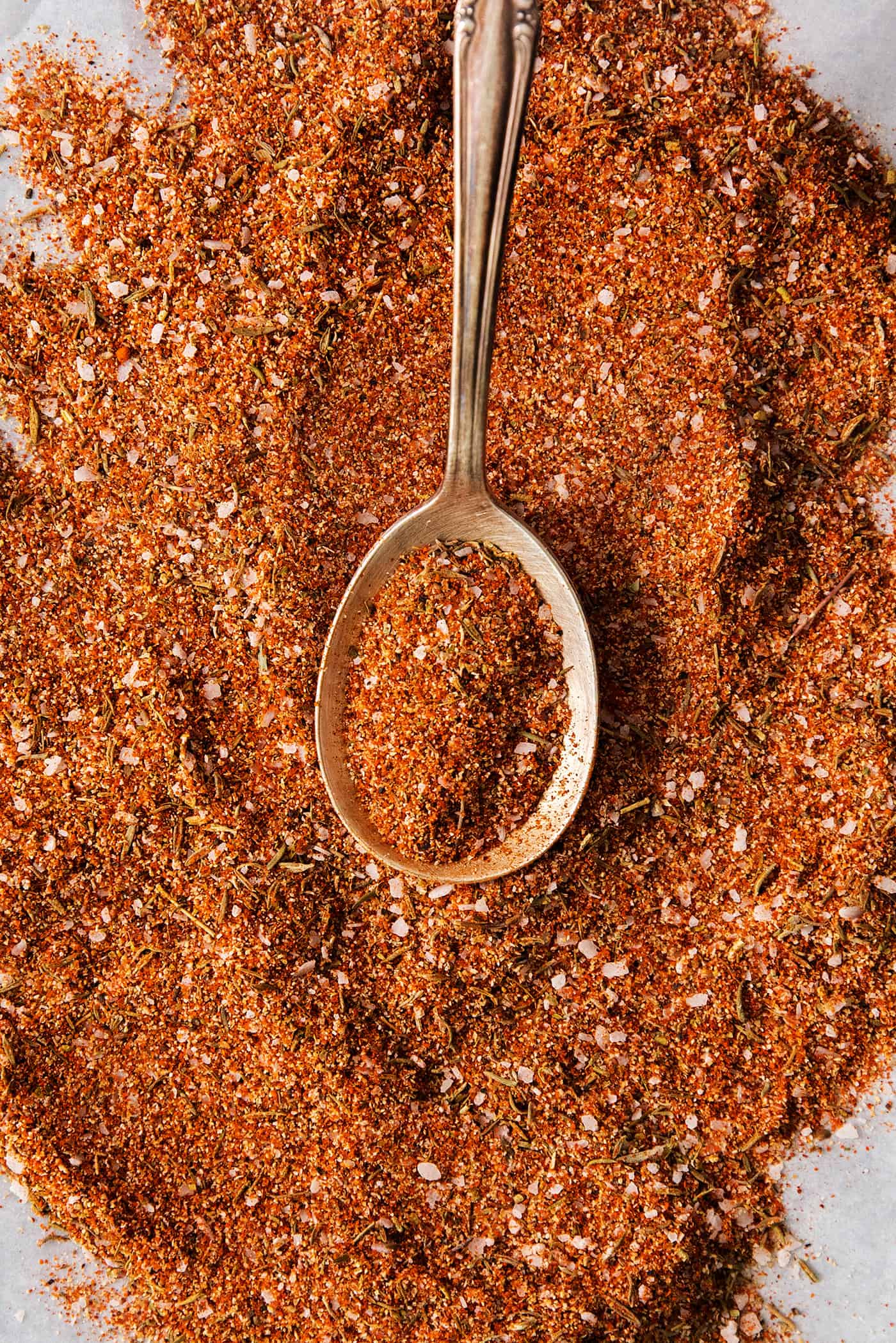 dried spices and herbs mixed, with a spoon