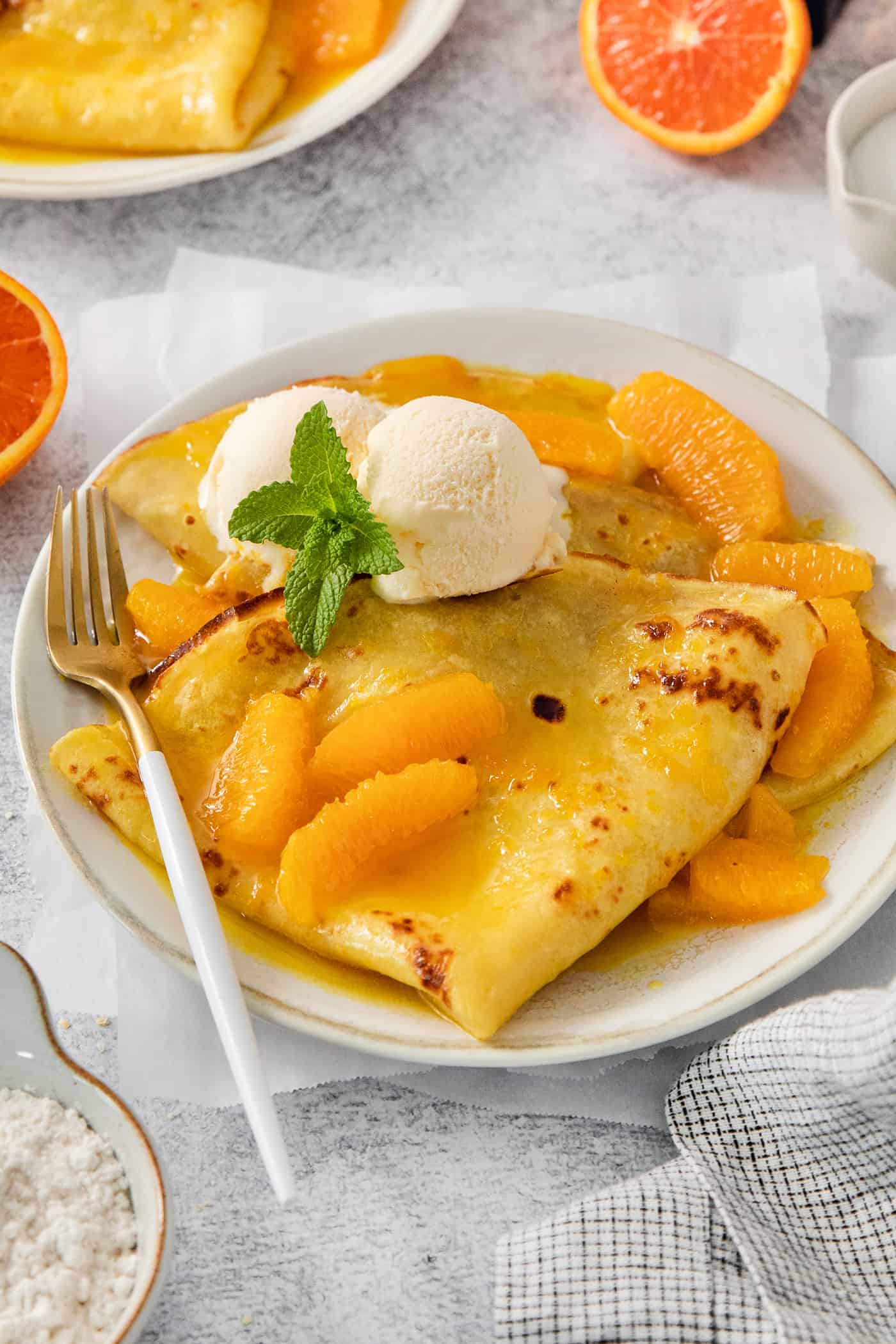 A fork rests on the side of a plate of crepes Suzette.