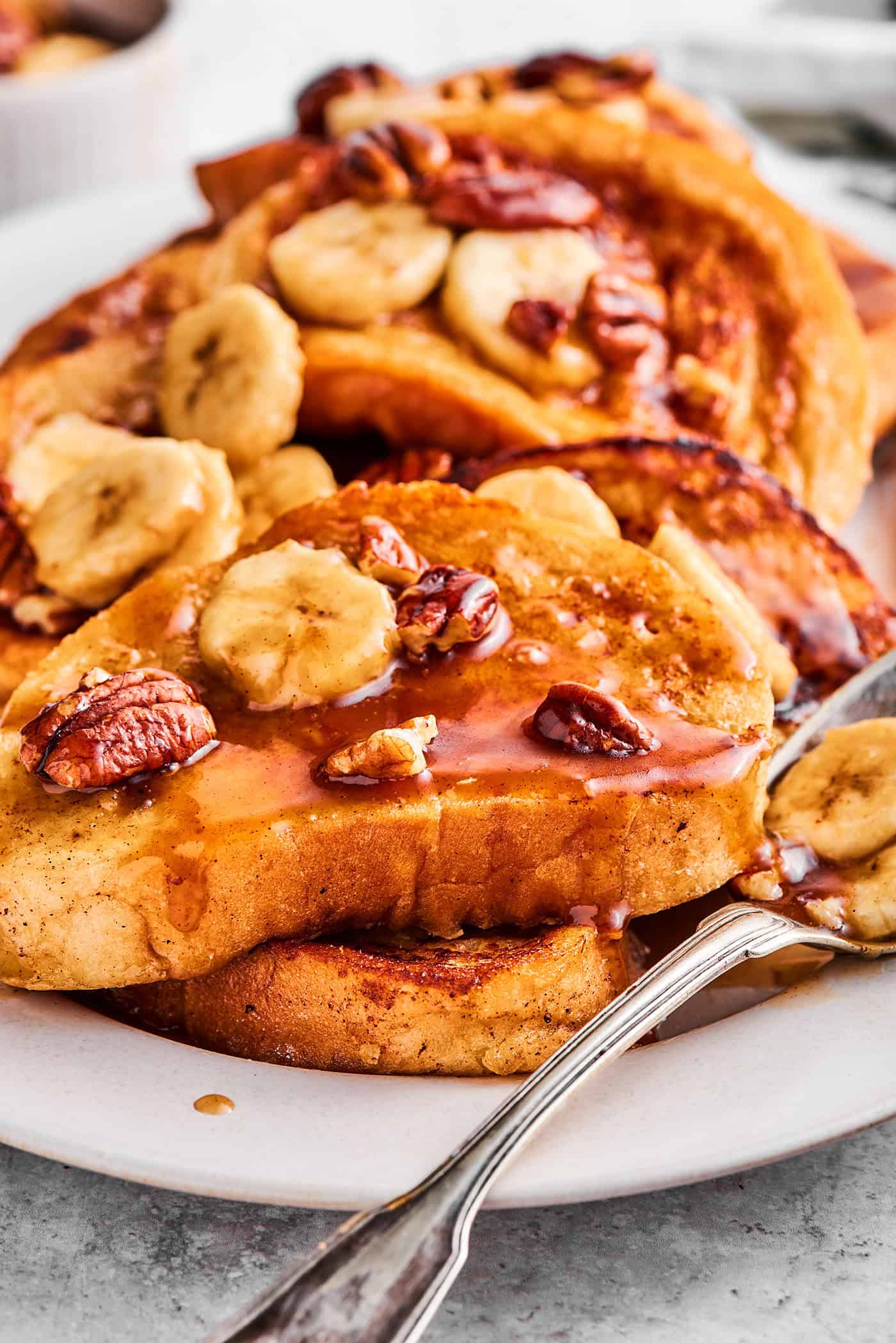 French toast with bananas foster sauce, layered on a white platter