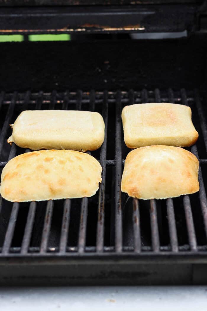 Ciabatta rolls toast on the grill.