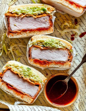 a tray of sliced pork katsu sandwiches with a bowl of sauce